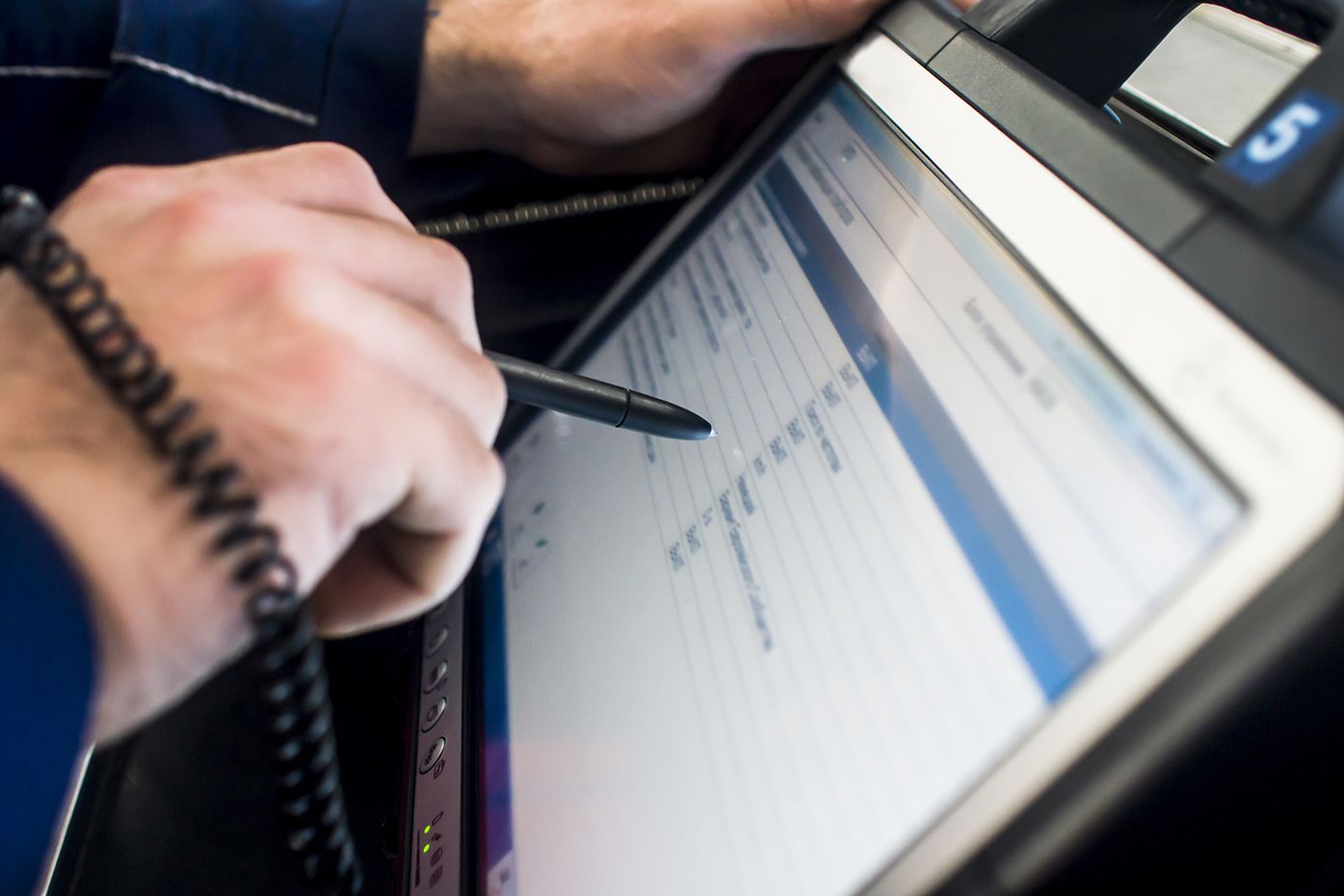 Eine Person nutzt einen Stift, um auf einem Tablet zu schreiben